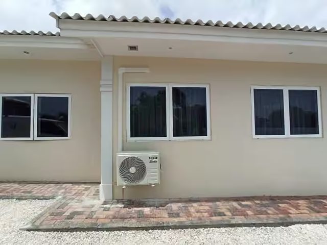 Outdoor condenser mounted under the overhang of a house